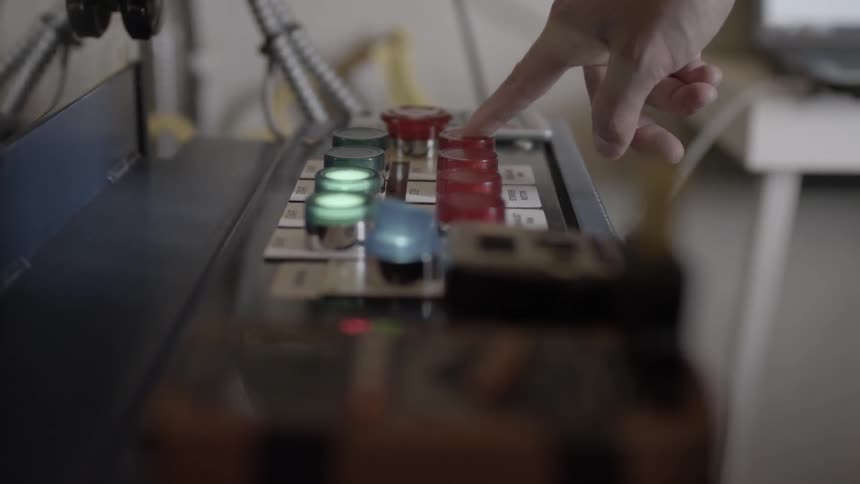 Person pushes a red button on top of a machine