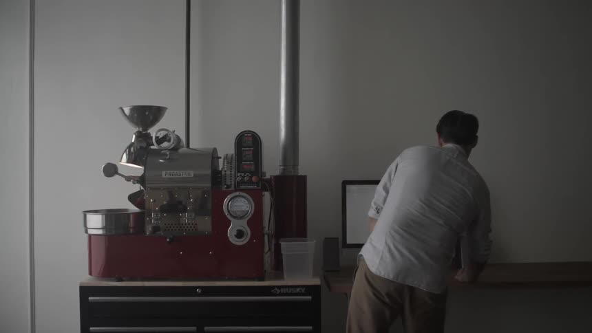 A man is working at a computer near some machinery