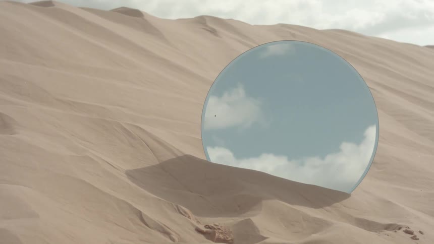 Round mirror in a sandy desert