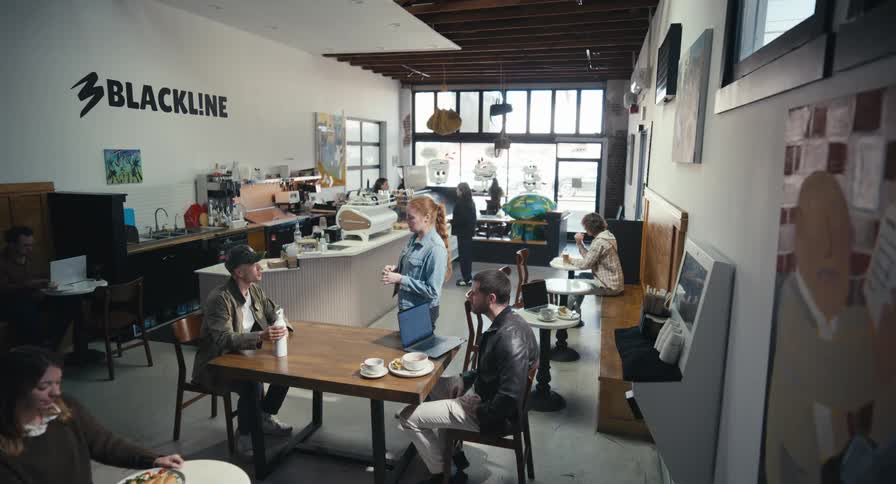 A high-angle wide shot of a contemporary and spacious coffee shop with various customers working, socializing, and enjoying their beverages
