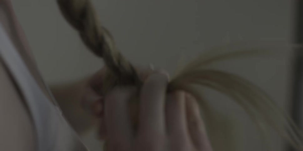 A woman braids her long hair