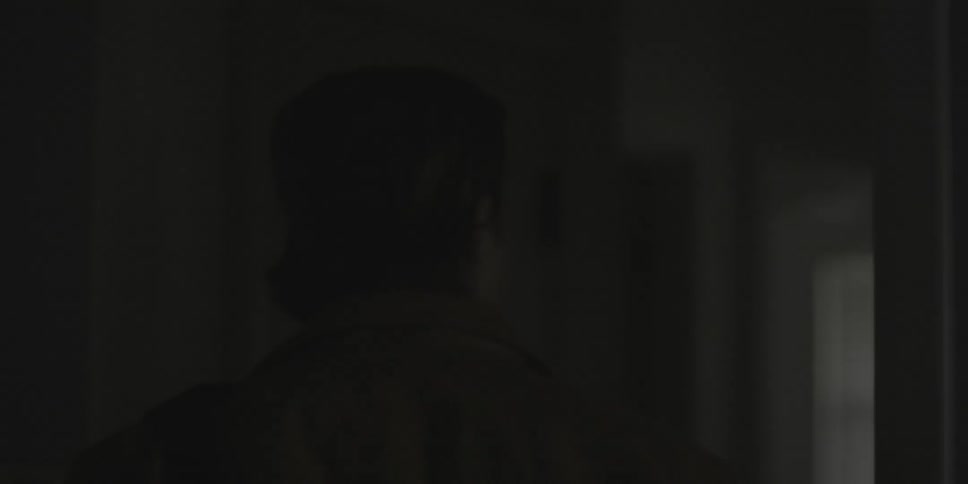 A man is walking through a house looking for something