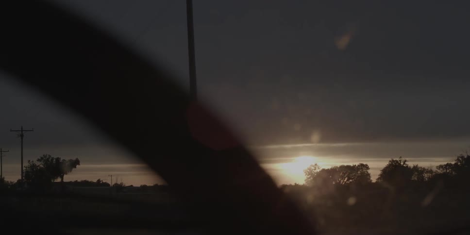 A long pole sits on a field at dawn