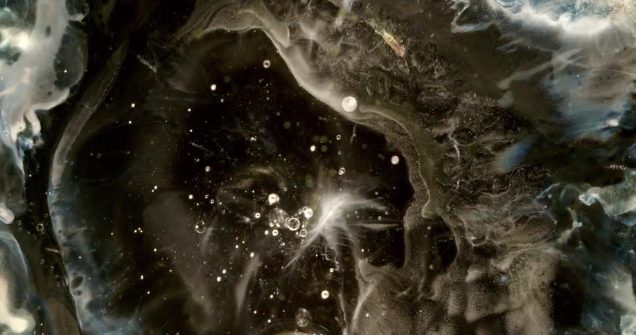 Cosmic abstract of swirling dark liquid and ethereal white smoke creating a galaxy effect