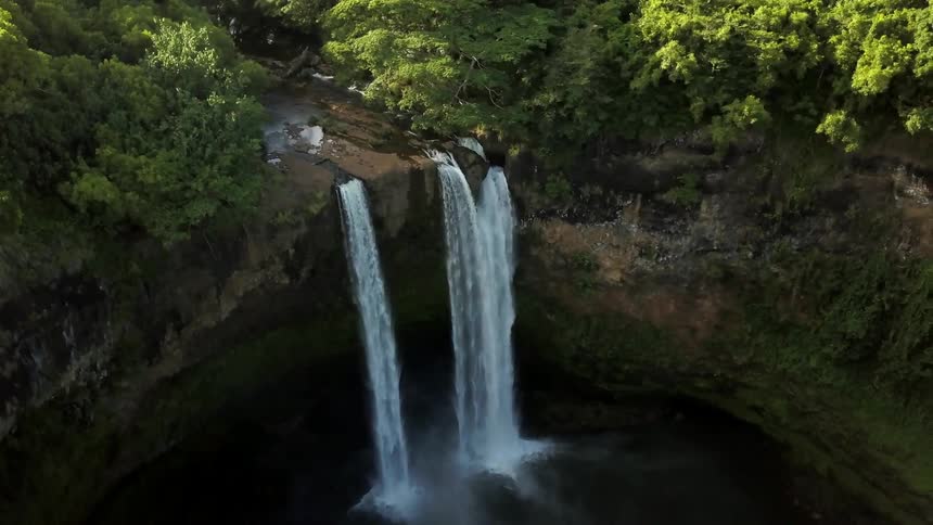 The waterfall pours off the cliff below