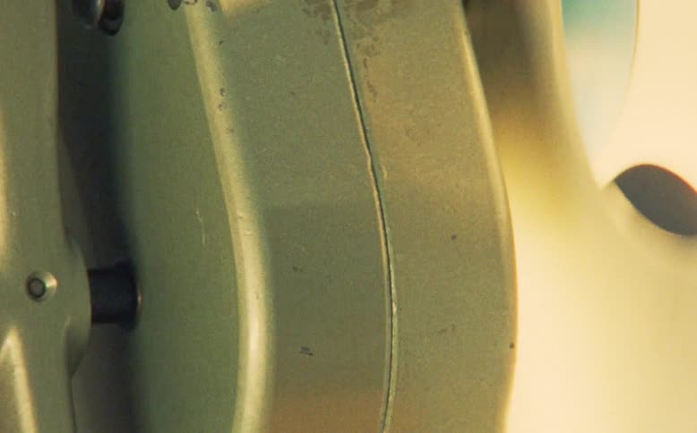 An extreme close-up of a person operating a vintage hand-cranked air raid siren