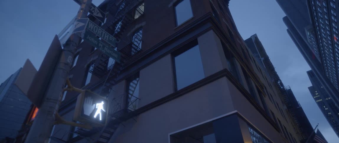 Lights shine on the side of a tall building at dawn