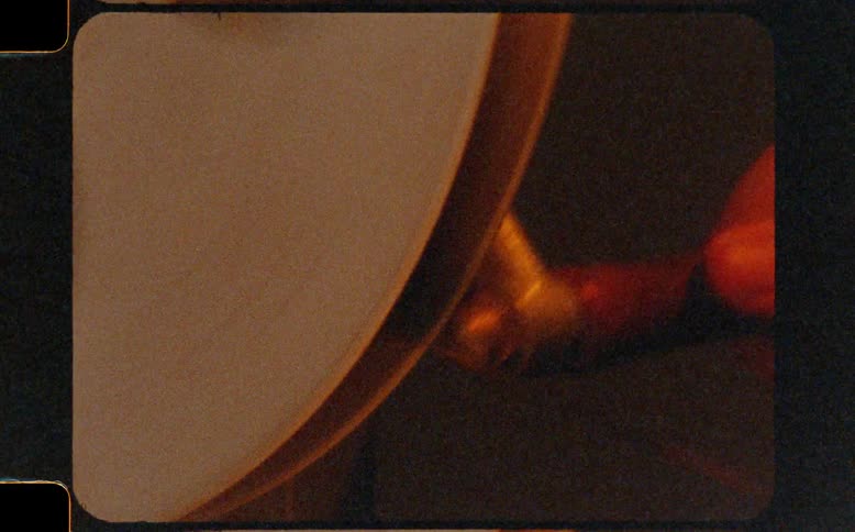 Vintage 8mm footage shows a close-up of a craftsman sharpening a tool on a grinding wheel