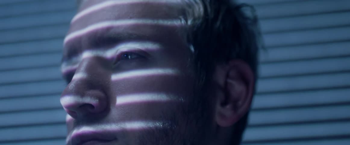Horizontal lights shine on a man's face