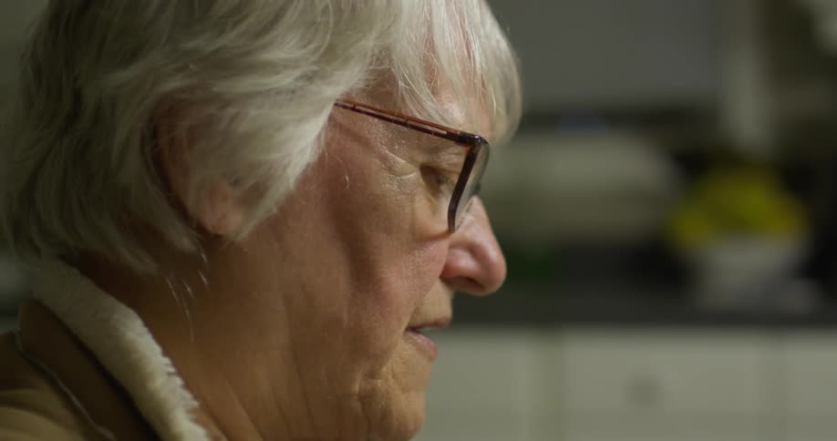 A woman in glasses looks down