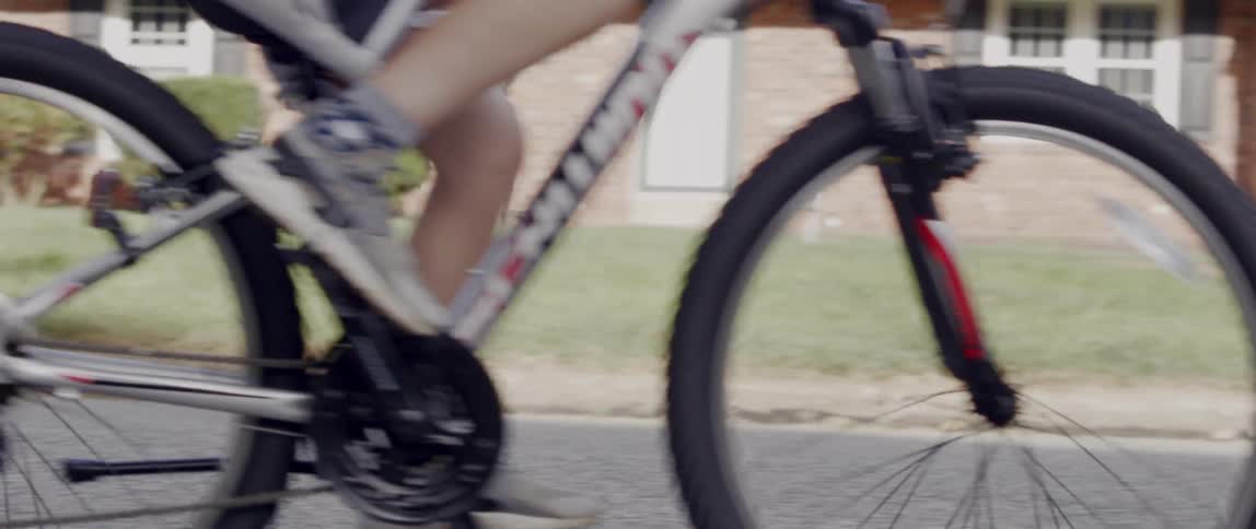 People ride bikes down a hill