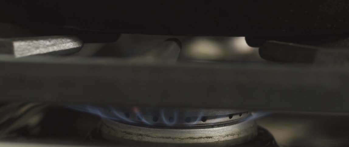 A flame ignites and burns on a stove