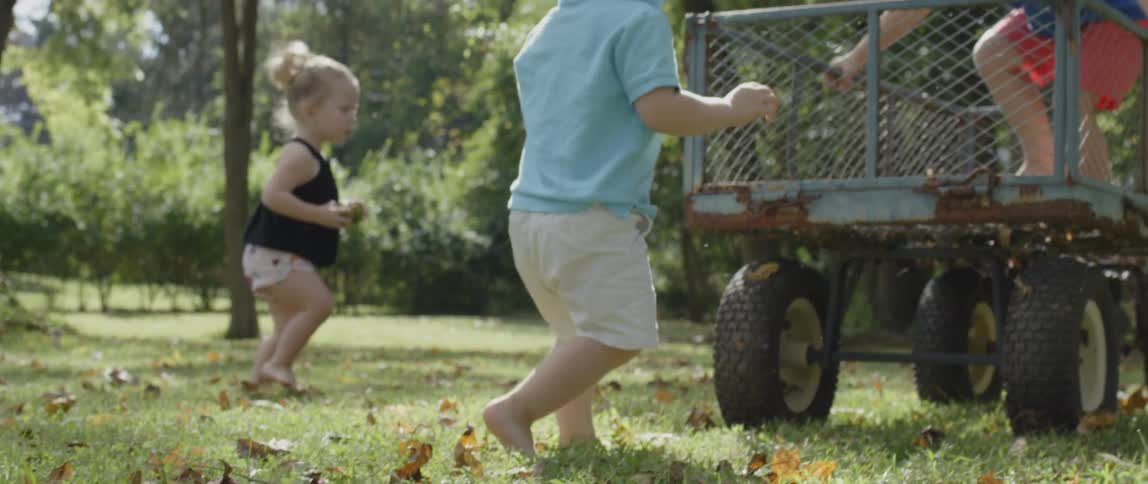 Two children walk towards a wagon