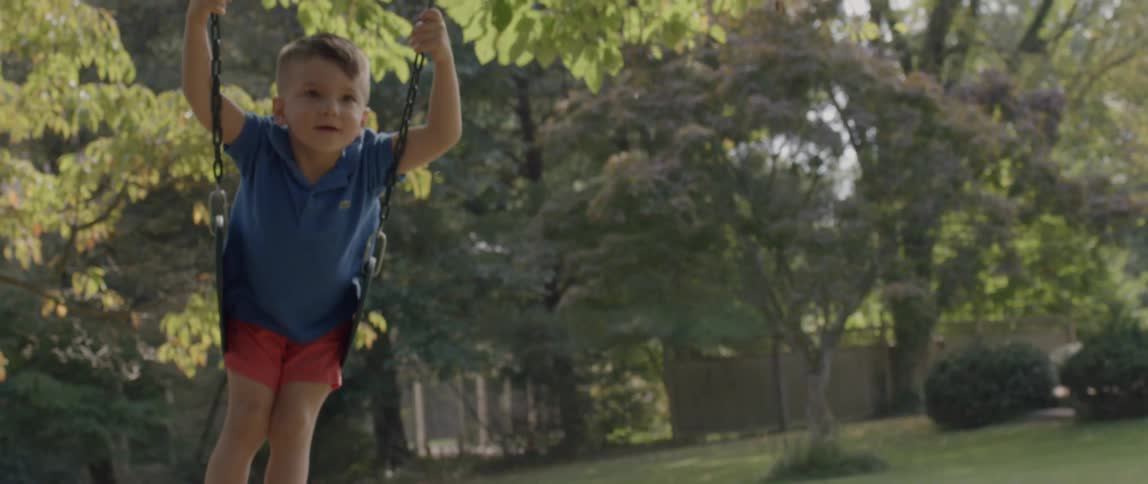 A little boy plays on a swing