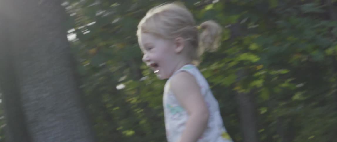 A blonde child runs outside