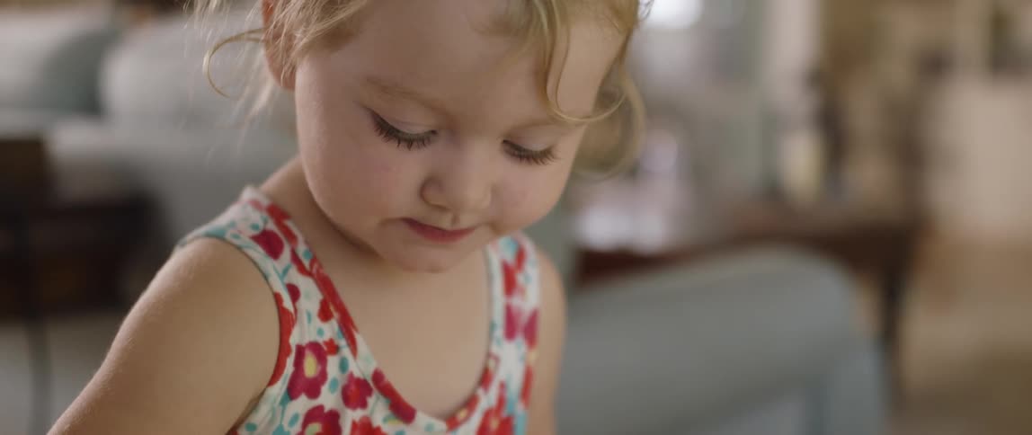 Smiling toddler looks down
