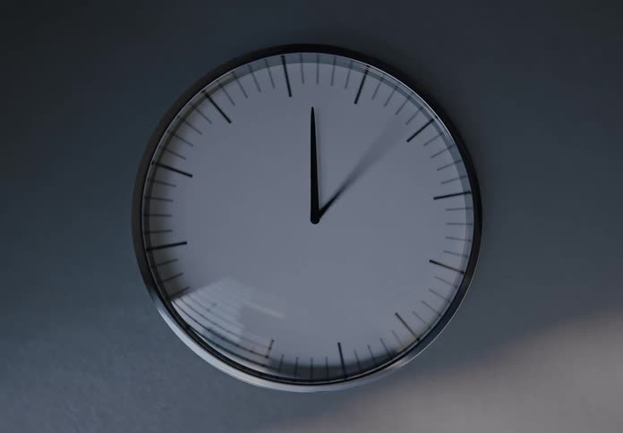 A time-lapse of a minimalist wall clock shows the passage of time as light and shadows move across its face from day to night