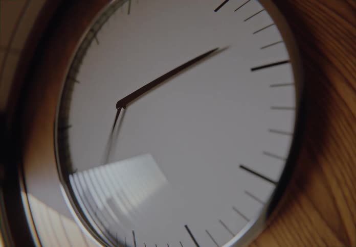 Extreme close-up fisheye time-lapse of a modern wall clock as time speeds by and day turns into night