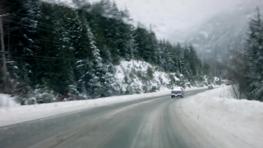 Cars ride down a snow covered road