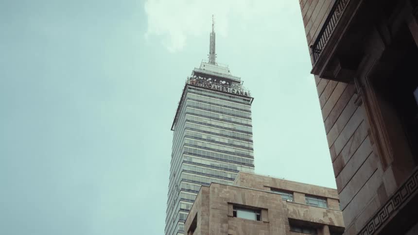 A low-angle shot of the iconic Torre Latinoamericana skyscraper framed by historic buildings in Mexico City