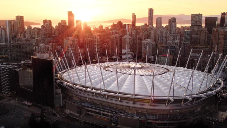 Stunning aerial view of BC Place stadium and the Vancouver skyline illuminated by a golden sunrise