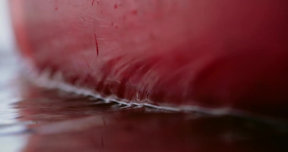 Water laps against a red object