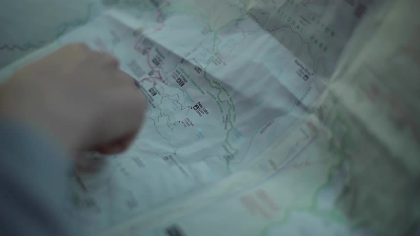 A finger points at a map