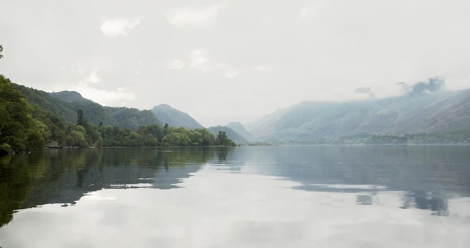 Foggy lake surrounded by mountains and forest