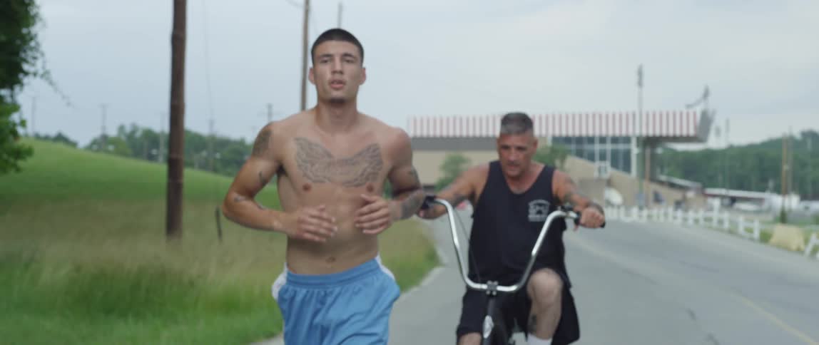 Men jogging and bicycling down a road
