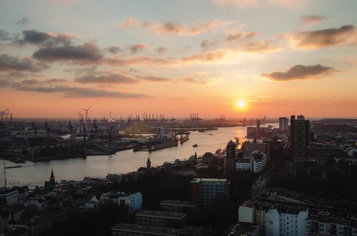 A stunning timelapse captures the sunset over the bustling industrial port city of Hamburg, Germany, as boats travel along the river