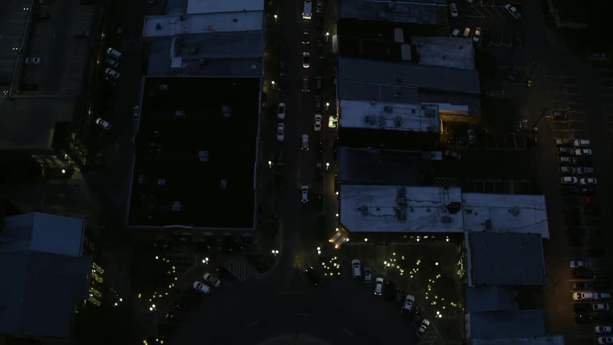 Cars travel in a roundabout with a lit christmas tree at its center