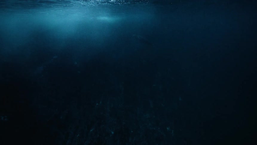Deep underwater view into the dark abyss of the ocean with faint light rays revealing a mysterious, slow-moving creature