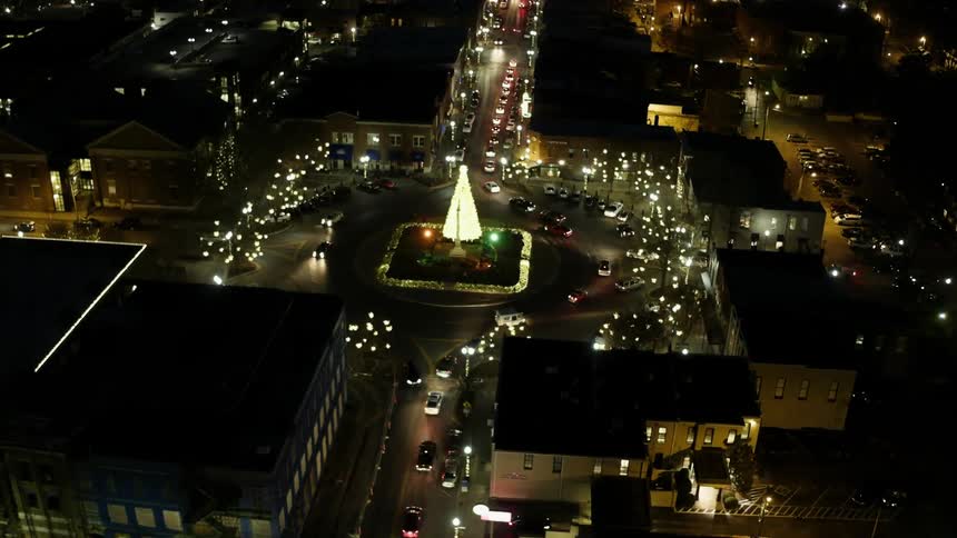 Bright lights on christmas tree in middle of city roundabout at night
