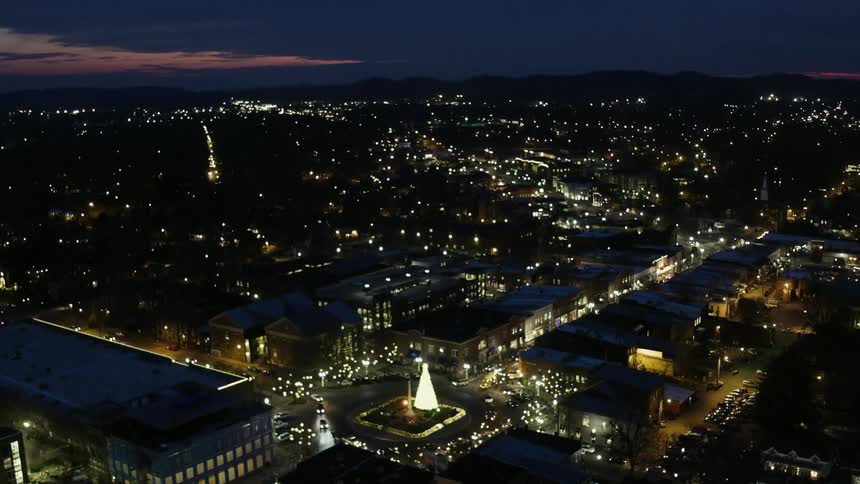 The city below is brightly lit at night