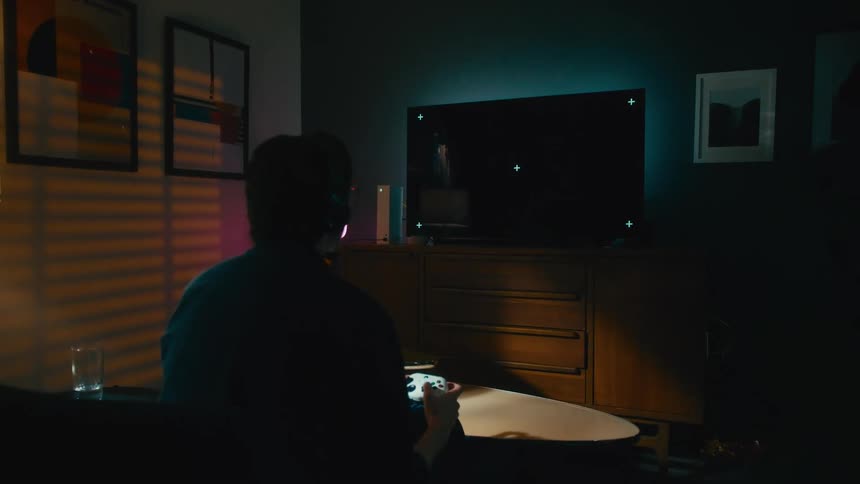 An angry gamer throws their hands up in frustration after losing a video game on a television with tracking markers