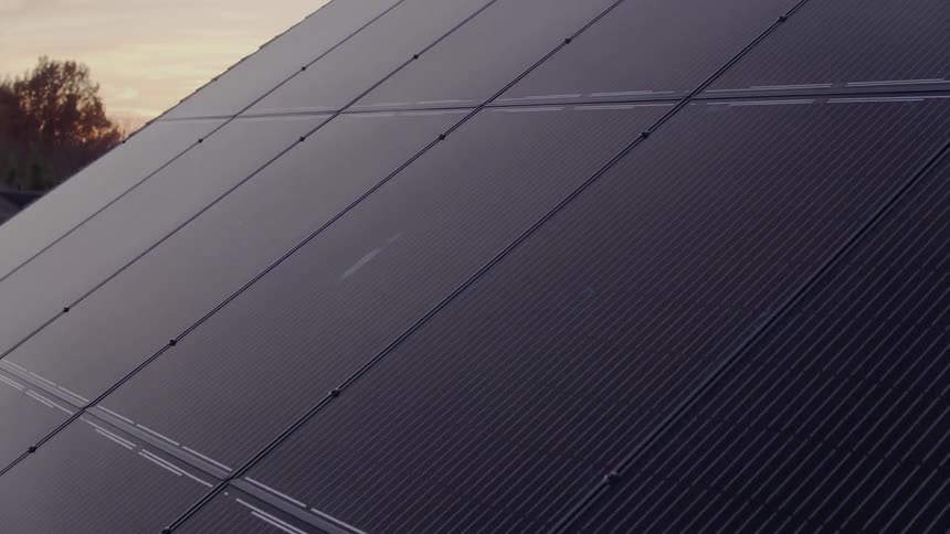 Solar panels sit atop a house in a suburban setting
