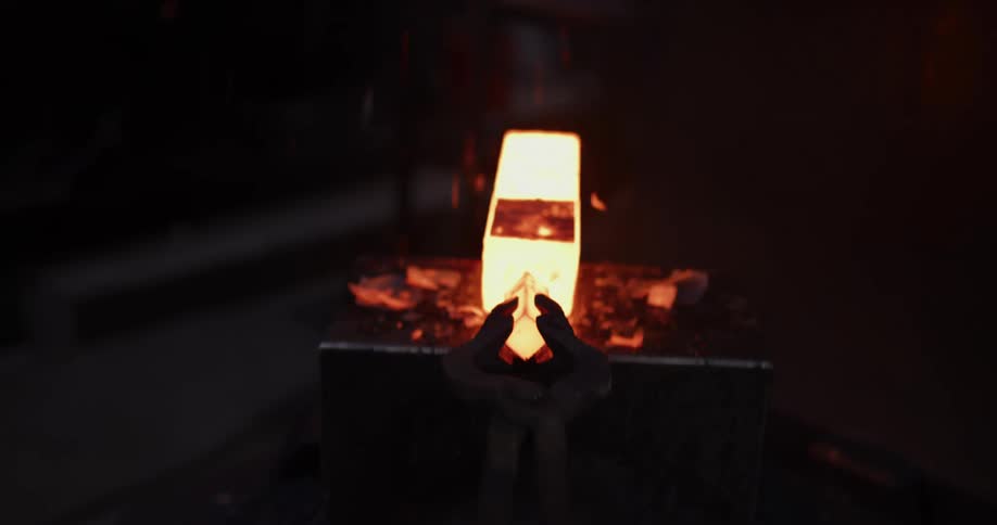 A blacksmith takes a glowing hot piece of steel from the furnace and forges it with a hydraulic press, sending sparks flying in a dark workshop