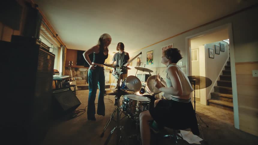 A youthful and energetic rock band passionately performs during a jam session in their home basement practice space