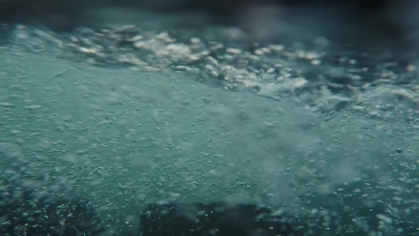 A chaotic and mesmerizing slow-motion journey through turbulent, bubbling water from an underwater perspective