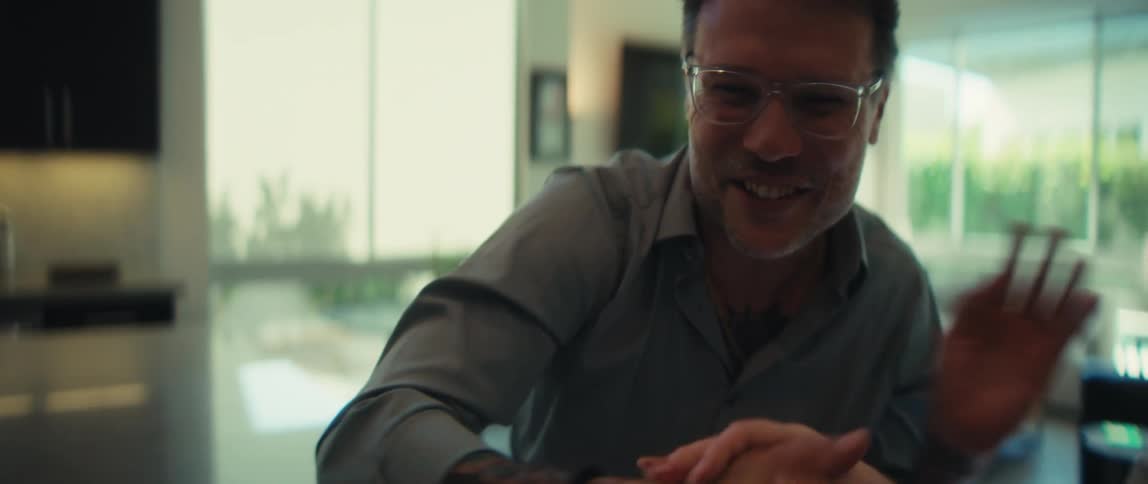 A friendly tattooed businessman and a female client finalize a deal with a handshake in a modern home office