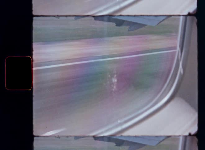 Archival footage from an airplane window shows the colorful, abstract motion blur of a runway during takeoff