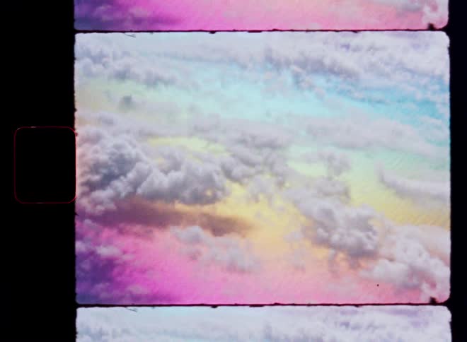 Dreamy, colorful clouds float by in a surreal aerial view captured on vintage film