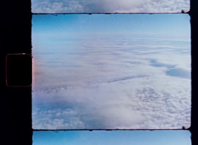 An aerial view of an endless sea of clouds on a sunny day, captured on vintage film