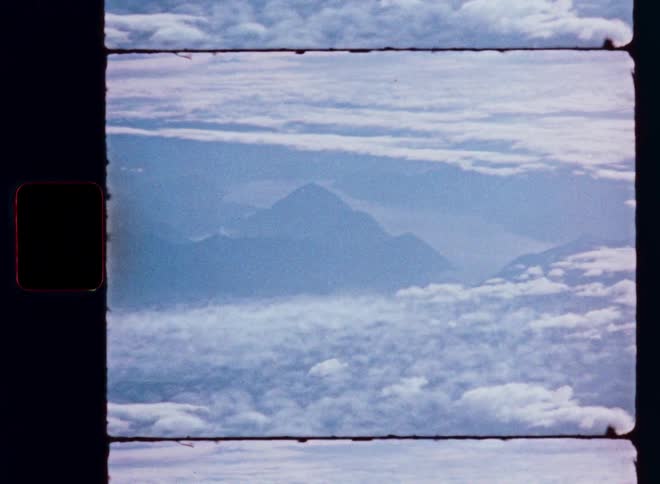 Super 8 film captures a view of distant mountains surrounded by a vast expanse of clouds