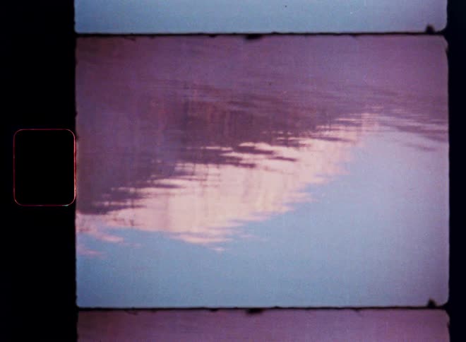 Abstract vintage film captures the reflection of a pastel-colored sky rippling on the surface of calm water