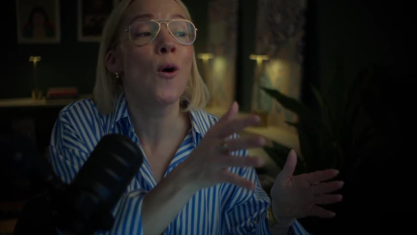 Slow zoom on a female podcaster passionately speaking into her microphone during a nighttime recording session