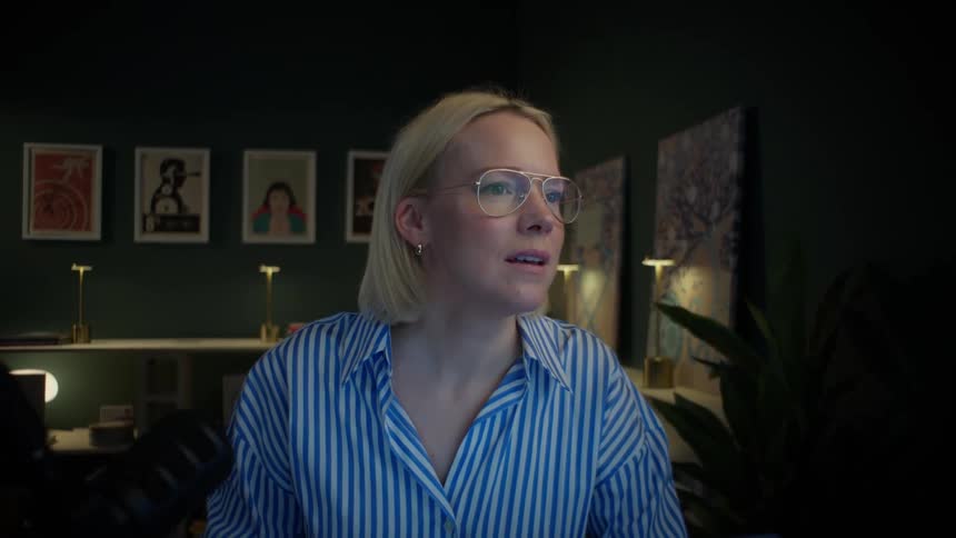 A woman working late in her home office studio has an emotional reaction to what she's seeing on her computer screen