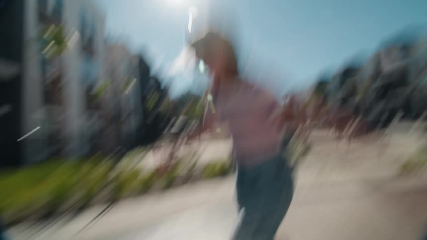 A dizzying, stylized low-angle shot follows a young girl roller skating through a sunny apartment complex courtyard