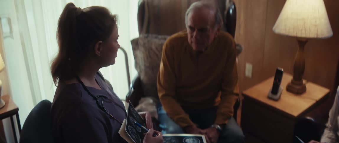 A dedicated healthcare provider reviews MRI results with a senior patient during a compassionate home visit