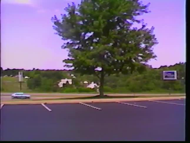 Vintage VHS footage from the 1990s pans across a parking lot before focusing on a custom purple semi-truck